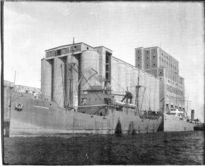 black and white image of elevator with ship docked