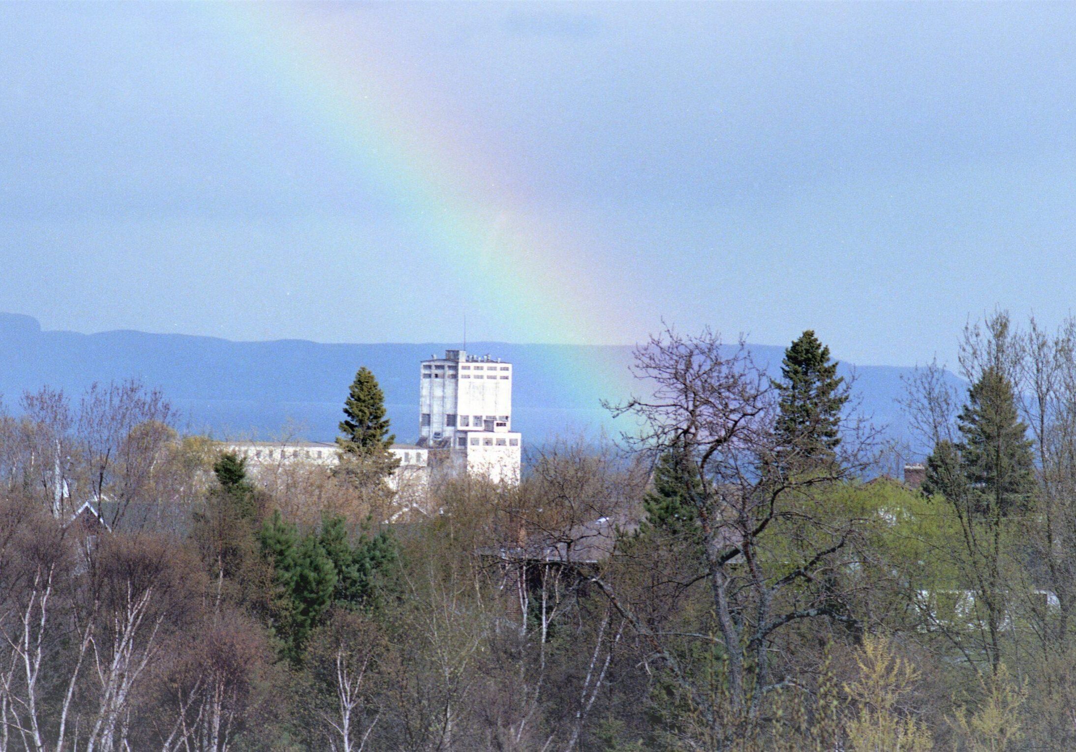 trees and elevator with rainbow shining through the sky