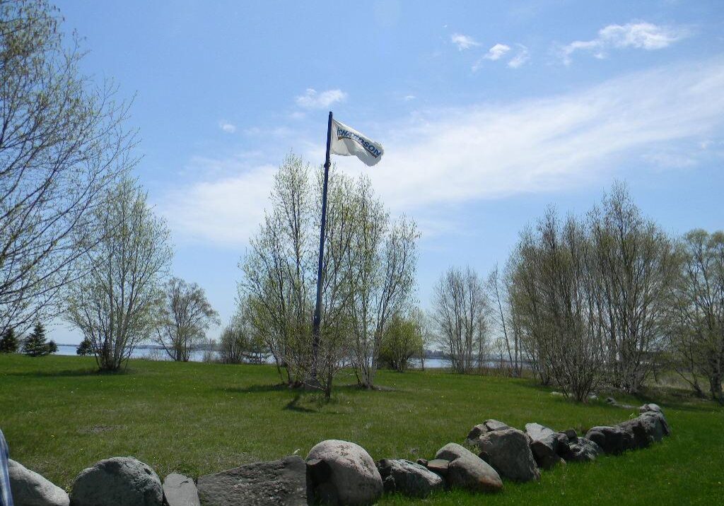eastern-richardson flag in grass surrounded by trees and rocks