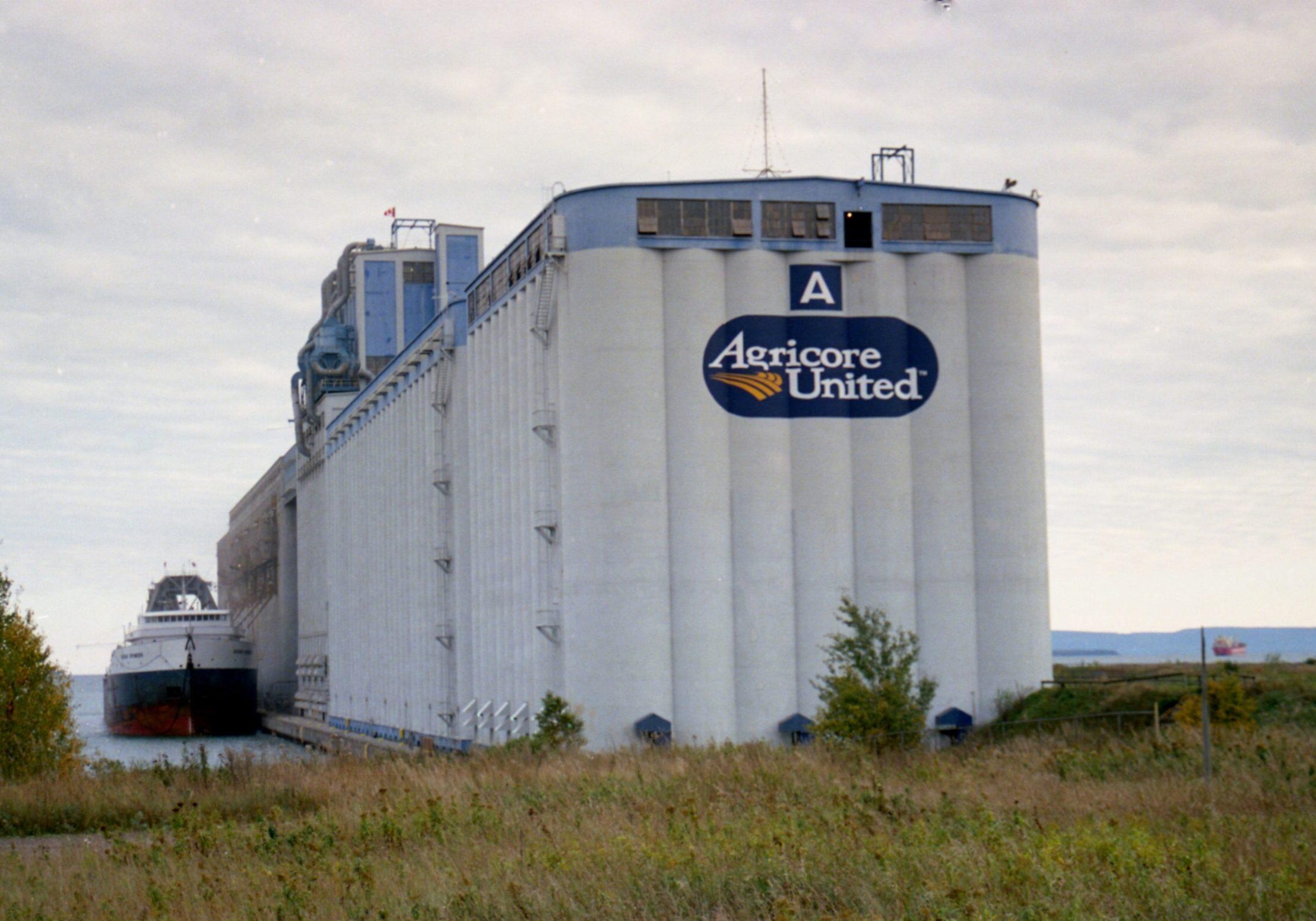image of back of elevator in the grass with "Agricore United" sign attached
