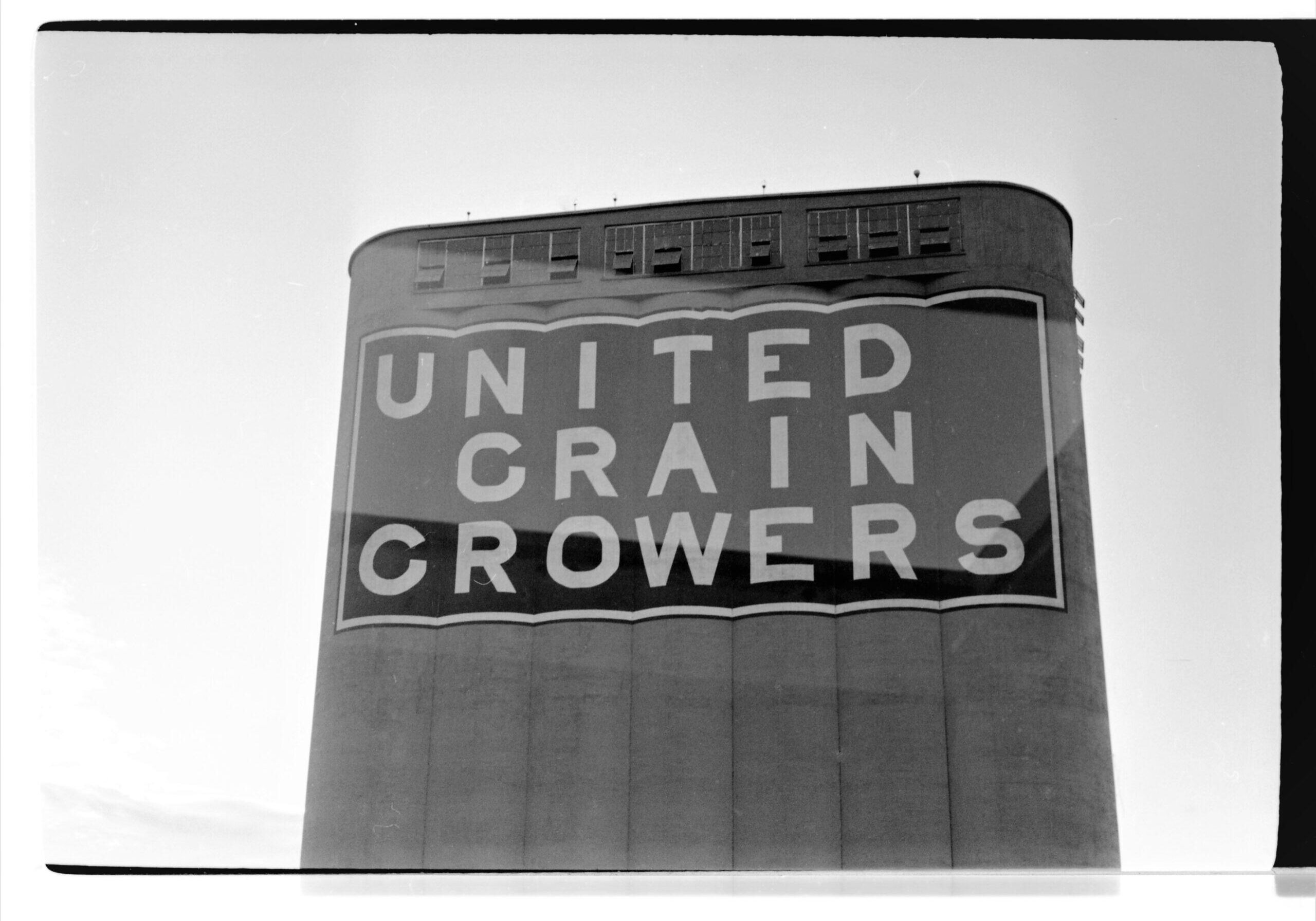 black and white close up of "United Grain Growers" sign on front of elevator